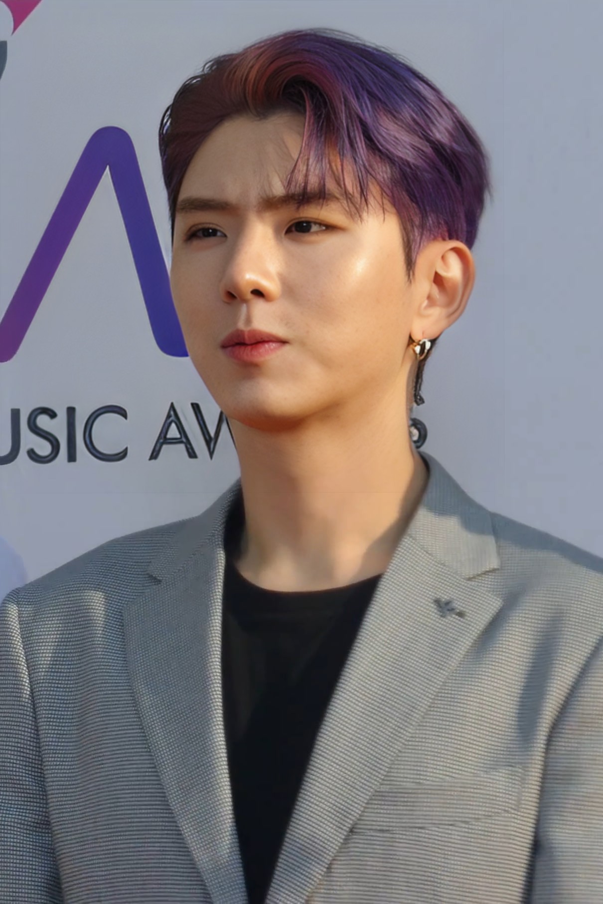 Kihyun de MONSTA X posando en una alfombra roja durante una premiación