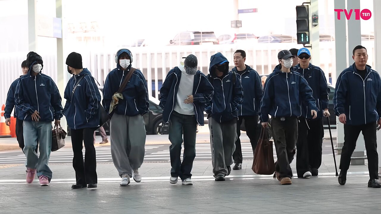 Los integrantes de BTS caminan juntos por el aeropuerto de Incheon con conjuntos deportivos azules antes de un vuelo en 2026
